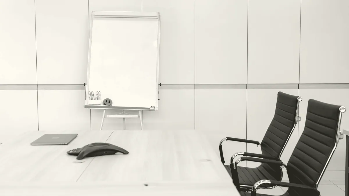 An empty meeting room with a whiteboard.