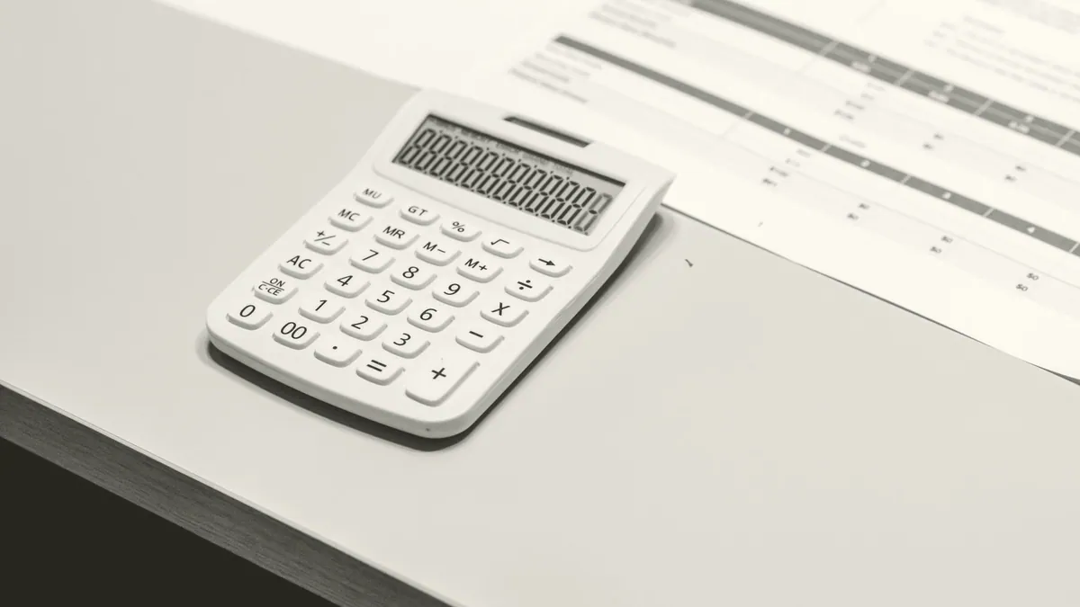 A printed spreadsheet and a calculator on a desk.