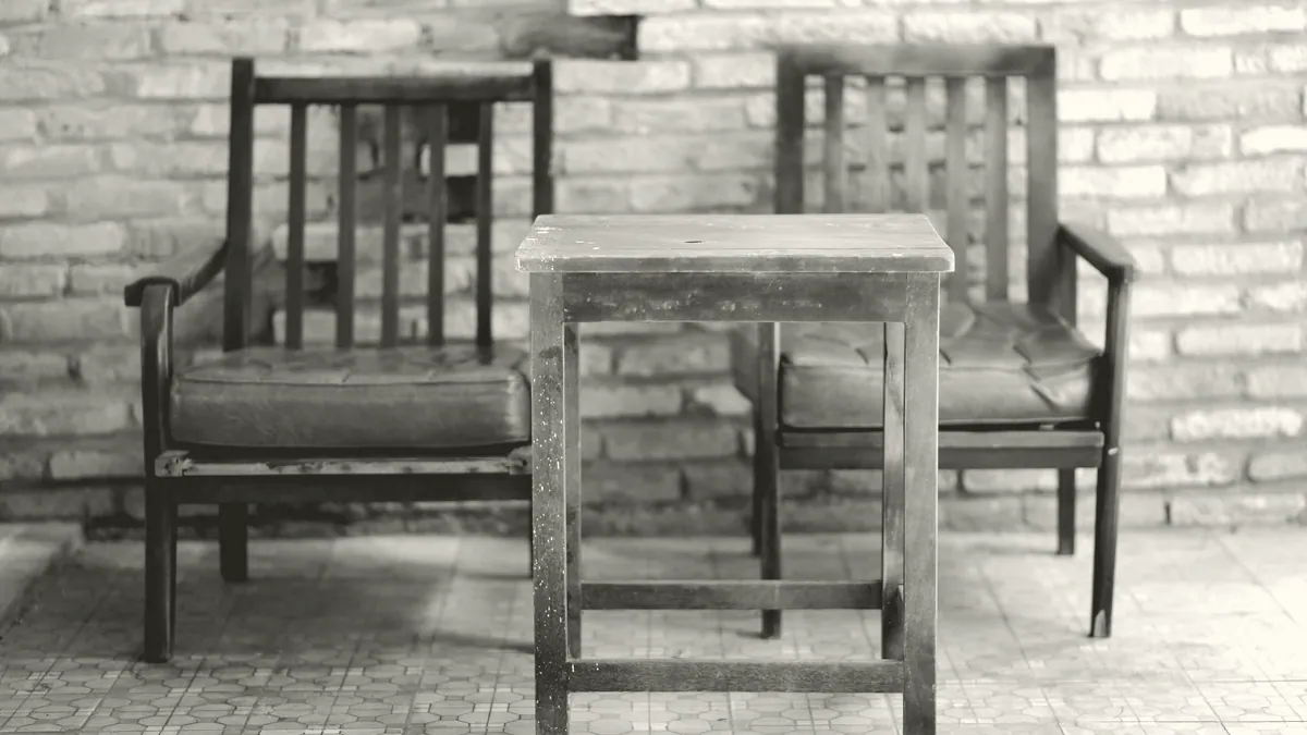 Two wooden chairs at a table.